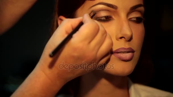 Afwerking voor de perfecte make-up. Glamour meisje met een avond make-up in een stoel van professionele make-up artiest — Stockvideo