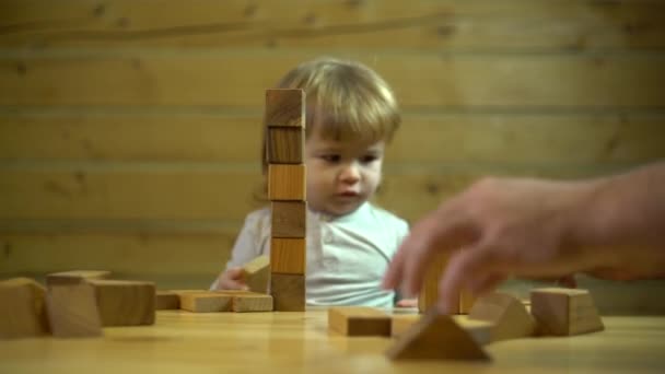 Blond baby boy constructing a toy house with his father — Stock Video