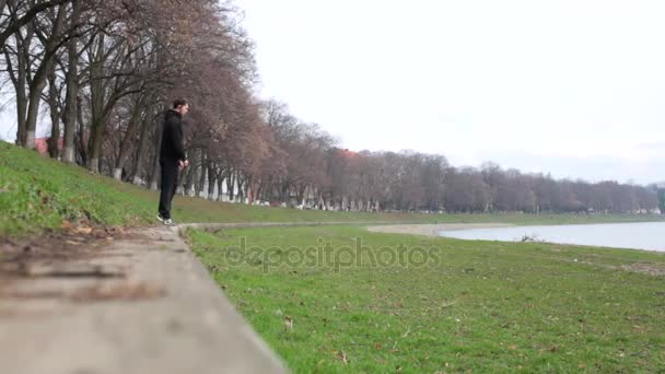 Primavera de gato y volando rollo de buceo delante de un deportista de parkour en traje deportivo negro — Vídeos de Stock