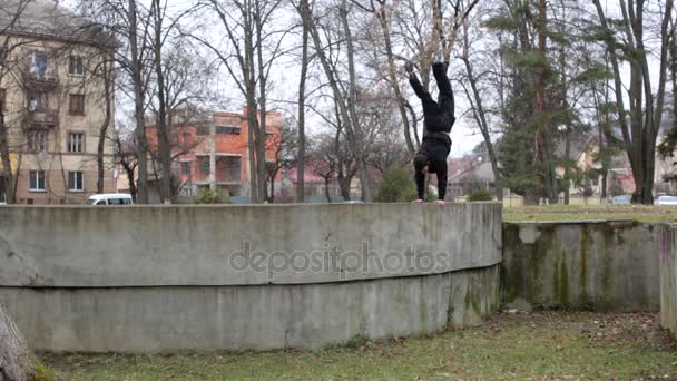 Упражнения на руках молодого спортсмена-паркура на городской площадке — стоковое видео