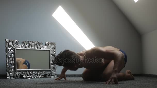 Αγόρι κάθεται λοξά τον καθρέφτη και κάνοντας πλαστικές κινήσεις με κάθε του μυς — Αρχείο Βίντεο