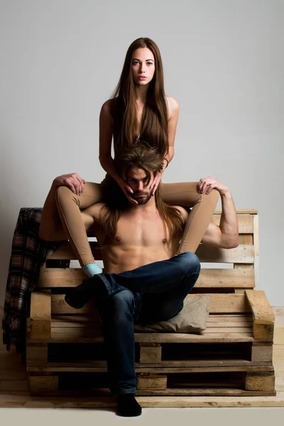 Νεαρό ζευγάρι στο ξύλινος καναπές — Φωτογραφία Αρχείου
