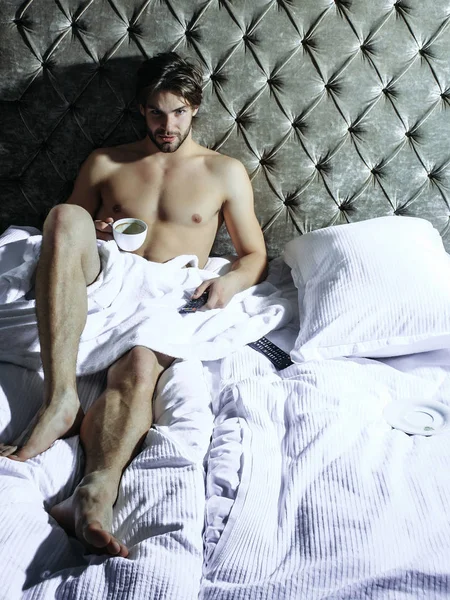 bearded man on bed with coffee