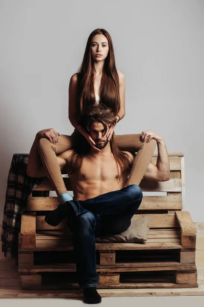 Jovem casal no sofá de madeira — Fotografia de Stock