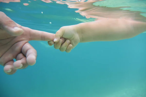 Baby och fäder händer i vatten — Stockfoto
