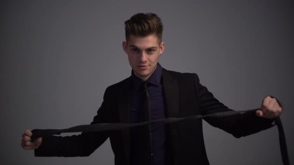 Attractive guy and a black tie. The young man learns to tie a necktie — Stock Video