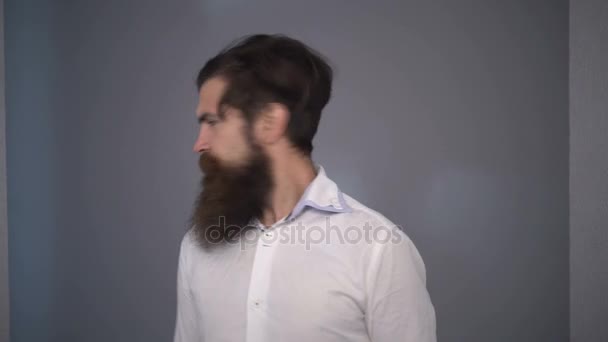 Бородатий чоловік повертає голову довгим волоссям. Модна зачіска в перукарні для бородатих — стокове відео