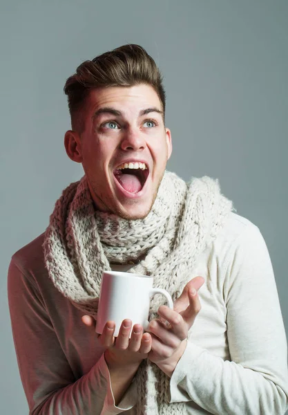 Красивый парень с чашкой в шарфе — стоковое фото