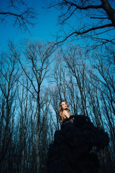 Elegante jonge vrouw in het bos — Stockfoto