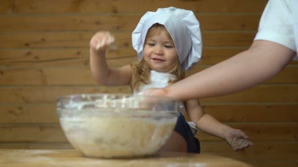Bébé en costume de chef jouant avec la farine à la cuisine — Video