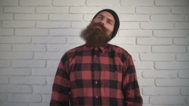 Başparmak gösterilmesini ekose gömlekli sakallı adam. İyi iş çıkardın. Adama göster başparmak yukarıya, beyaz duvara karşı iyi jest