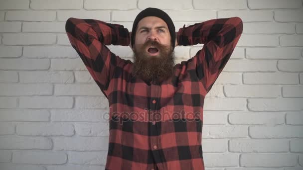 Человек с бородой зевает на улице. Бородатый парень хочет спать и зевает — стоковое видео
