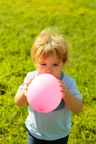 Bambino gioca con palloncino rosa giocattolo — Foto Stock