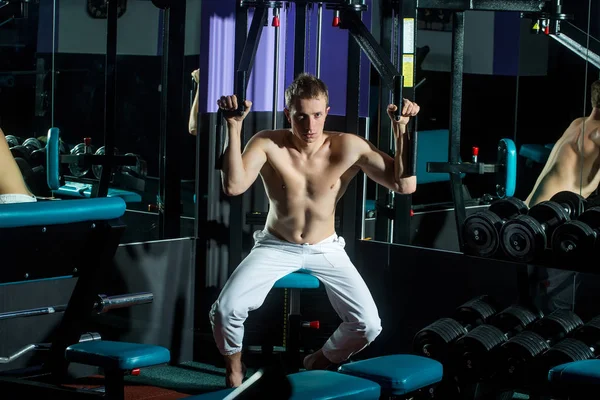 Sexy hombre con musculoso entrenamiento corporal levantamiento de pesas en gimnasio equipo —  Fotos de Stock