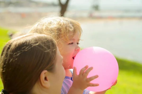 Mãe e filho com balão de brinquedo rosa — Fotografia de Stock