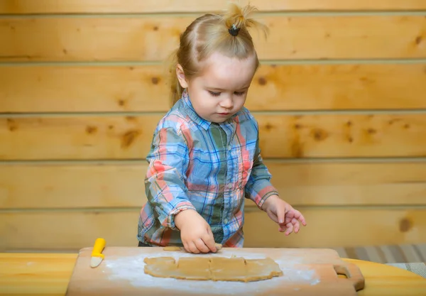 Cute child in checkered shirt cooking with dough and flour — Stock Photo, Image