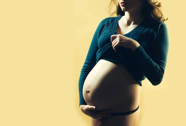 Mulher grávida bonita com barriga redonda nua no fundo amarelo — Fotografia de Stock