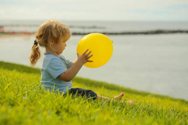Милый мальчик с жёлтым игрушечным шариком — стоковое фото