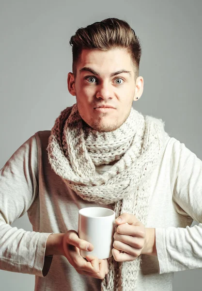 Красивый парень с чашкой в шарфе — стоковое фото