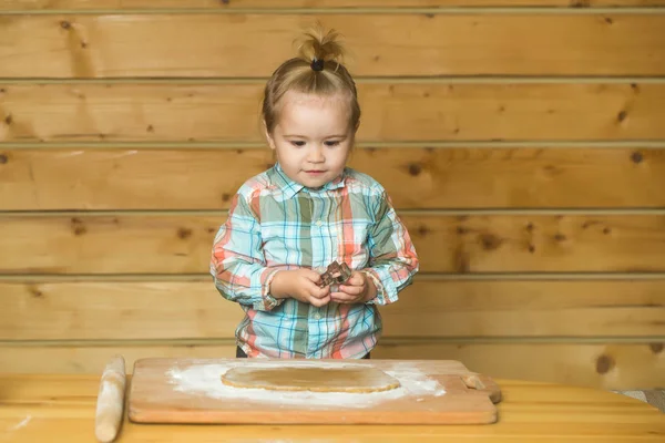 Lindo niño cocinando con masa y harina, sostiene el molde metálico — Foto de Stock