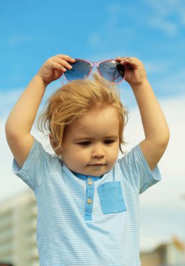 Şirin bebek çocuk moda güneş gözlüğü kafasına koyar.