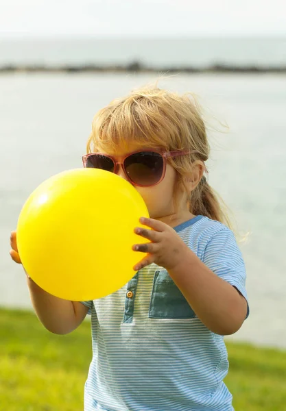 黄色の風船で遊ぶかわいい赤ちゃんの少年 — ストック写真