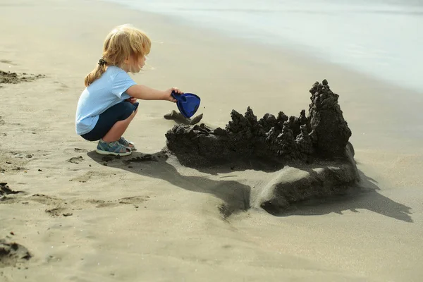 かわいい男の子海のビーチで砂の城を構築します。 — ストック写真