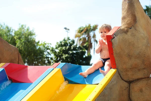 Bang schattige babyjongen zit op de top van glijbaan — Stockfoto