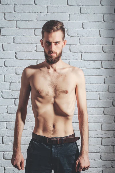 Slim vousatý muž s tenkou holé torzo na cihlové pozadí — Stock fotografie