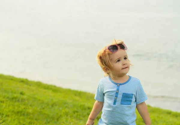 Милый мальчик в модных солнечных очках на голове — стоковое фото