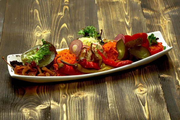 Вкусные маринованные овощи на тарелке — стоковое фото