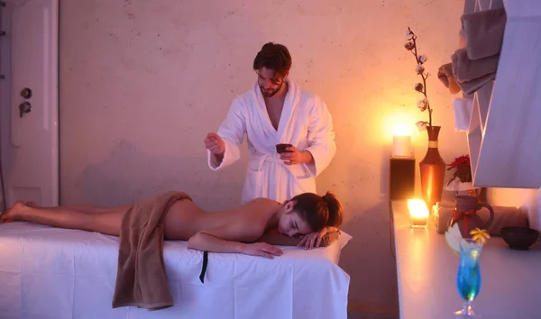 Sexig kvinna på spa salon massage med skäggiga stilig terapeut — Stockfoto