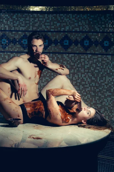 Izmos férfi és szexi nő enni csokoládé masszázs szalon után — Stock Fotó