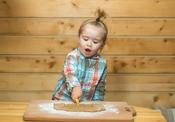 Cute child in checkered shirt cooking with dough and flour — Stock Photo, Image