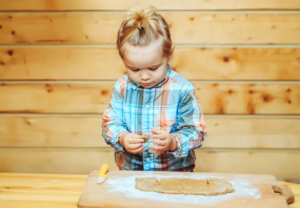 Cute child in checkered shirt cooking with dough and flour — Stock Photo, Image