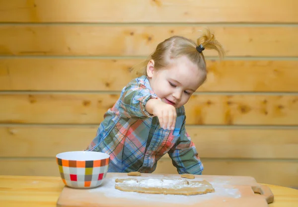 Carino bambino cucina con pasta, farina e ciotola su legno — Foto Stock