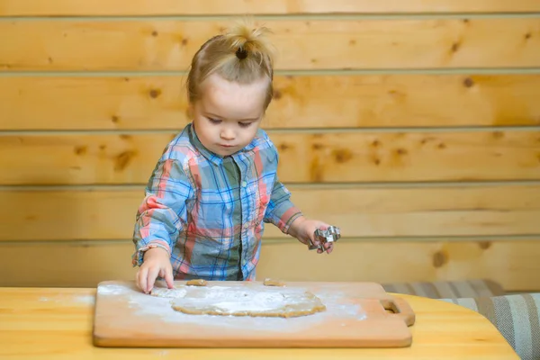 Cute child cooking with dough and flour, holds metallic mold — Stock Photo, Image