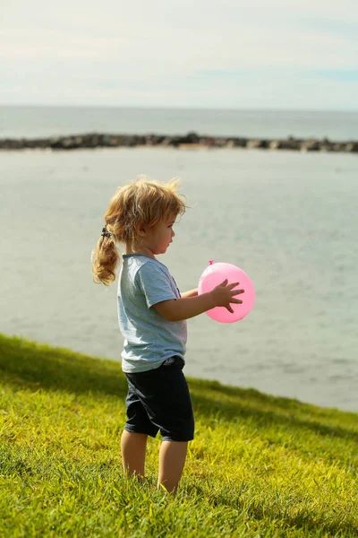 Lindo bebé niño juega con rosa juguete globo —  Fotos de Stock