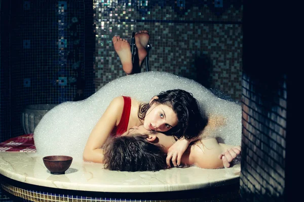 Kaslı erkek ve seksi kadın köpük banyosunda döşeme — Stok fotoğraf