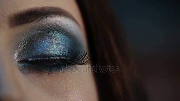 Κοντινό ανοιχτό μάτι με το μακιγιάζ. Γυναικεία μάτια με Βραδινό μακιγιάζ και μπλε σκιές και ψεύτικες βλεφαρίδες. Κοιτάζοντας έξω από κάτω από μακριές βλεφαρίδες — Αρχείο Βίντεο