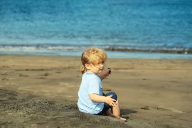 Şirin bebek çocuk kum kum plajındaki oturur