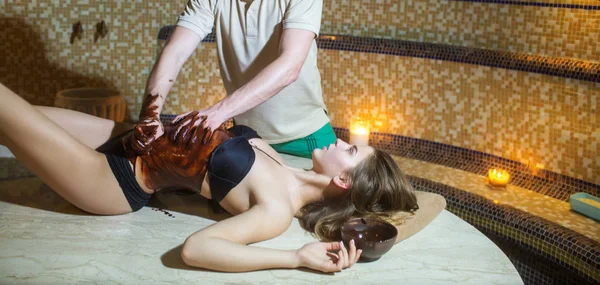 Sexig kvinna på spasalong choklad massage med manliga händer — Stockfoto