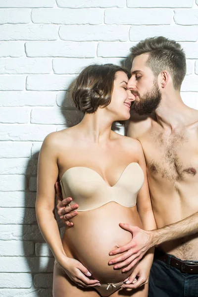 Bärtiger schlanker Mann und hübsche schwangere Frau mit rundem Bauch — Stockfoto