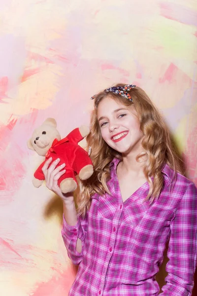 Щаслива красива дівчина посміхається з милим плюшевим ведмедем у червоному — стокове фото