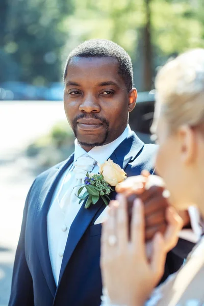 Handsome african American groom looks at adorable bride