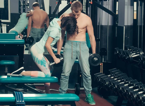 Musculoso homem e menina no ginásio com halteres — Fotografia de Stock