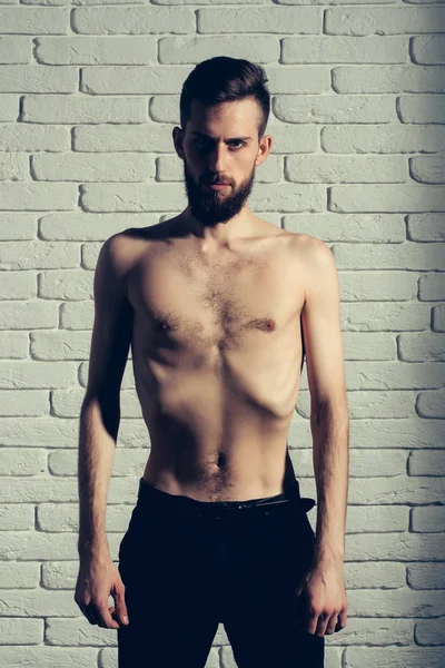 Slim vousatý muž s tenkou holé torzo na cihlové pozadí — Stock fotografie