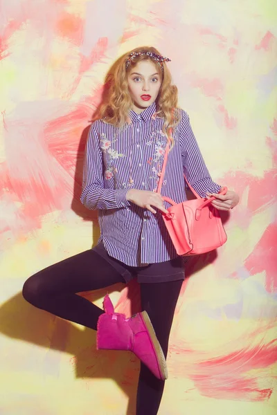 Verbaasd mooi meisje in roze ugg laarzen met stijlvolle tas — Stockfoto