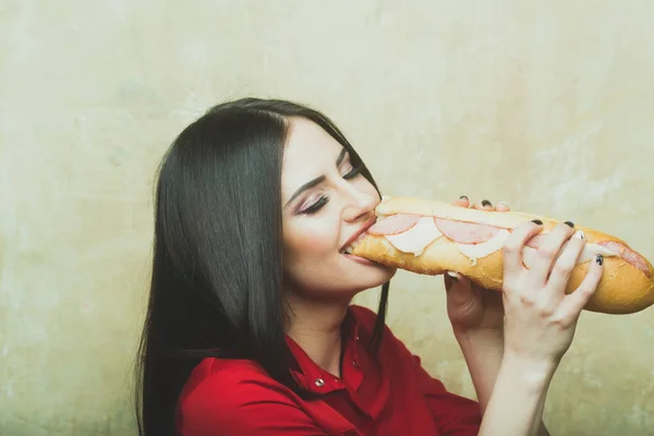 Seksi güzel esmer gülümseyen kadın koca sandviç ya da hamburger yiyor — Stok fotoğraf