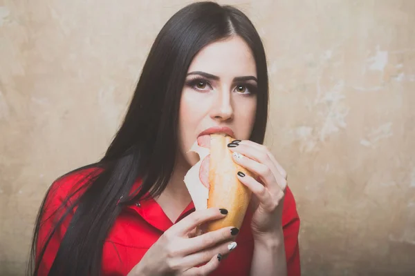 Сексуальна красива брюнетка жінка їсть великий бутерброд або бургер — стокове фото